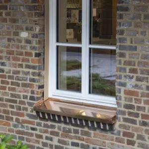 Holzfenster in weiß Weißes Holzfenster mit Sprossen und Fensterbank aus Kupfer