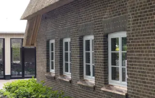 Holzfenster in weiß Weißes Holzfenster mit Sprossen und Fensterbank aus Kupfer