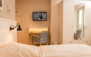 Schreibtisch und Kleiderschrank mit Lüftungsschlitzen für den Einbau einer Minibar, Hotel Mingers, Neuharlingersiel