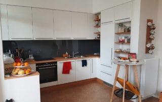 Moderne und helle Küche in U-Form in weiß mit Arbeitsplatte aus Massivholz Moderne und helle Küche in U-Form in weiß mit Arbeitsplatte aus Massivholz