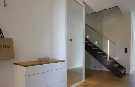 Garderobe mit beleuchtetem Spiegelschrank mit weißen Fronten maßangefertigt Privatkunde ullmann tischlerei Oldenburg Garderobe mit Spiegelschrank mit weißen Fronten Eiche massiv Akzenten maßangefertigt Flur Garderobe ullmann tischlerei Oldenburg