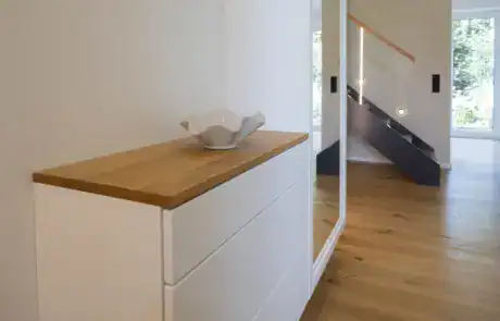 Garderobe mit beleuchtetem Spiegelschrank mit weißen Fronten maßangefertigt Privatkunde ullmann tischlerei Oldenburg Garderobe mit Spiegelschrank mit weißen Fronten Eiche massiv Akzenten maßangefertigt Flur Garderobe ullmann tischlerei Oldenburg